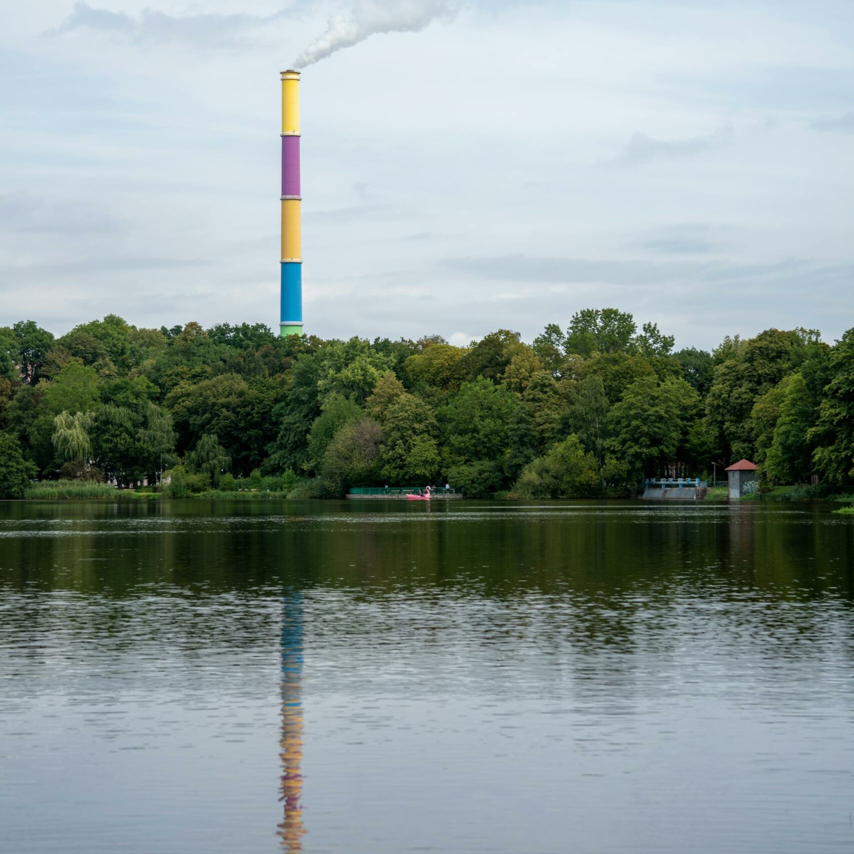 Industrial Chimney on Lake and Forest Landscape